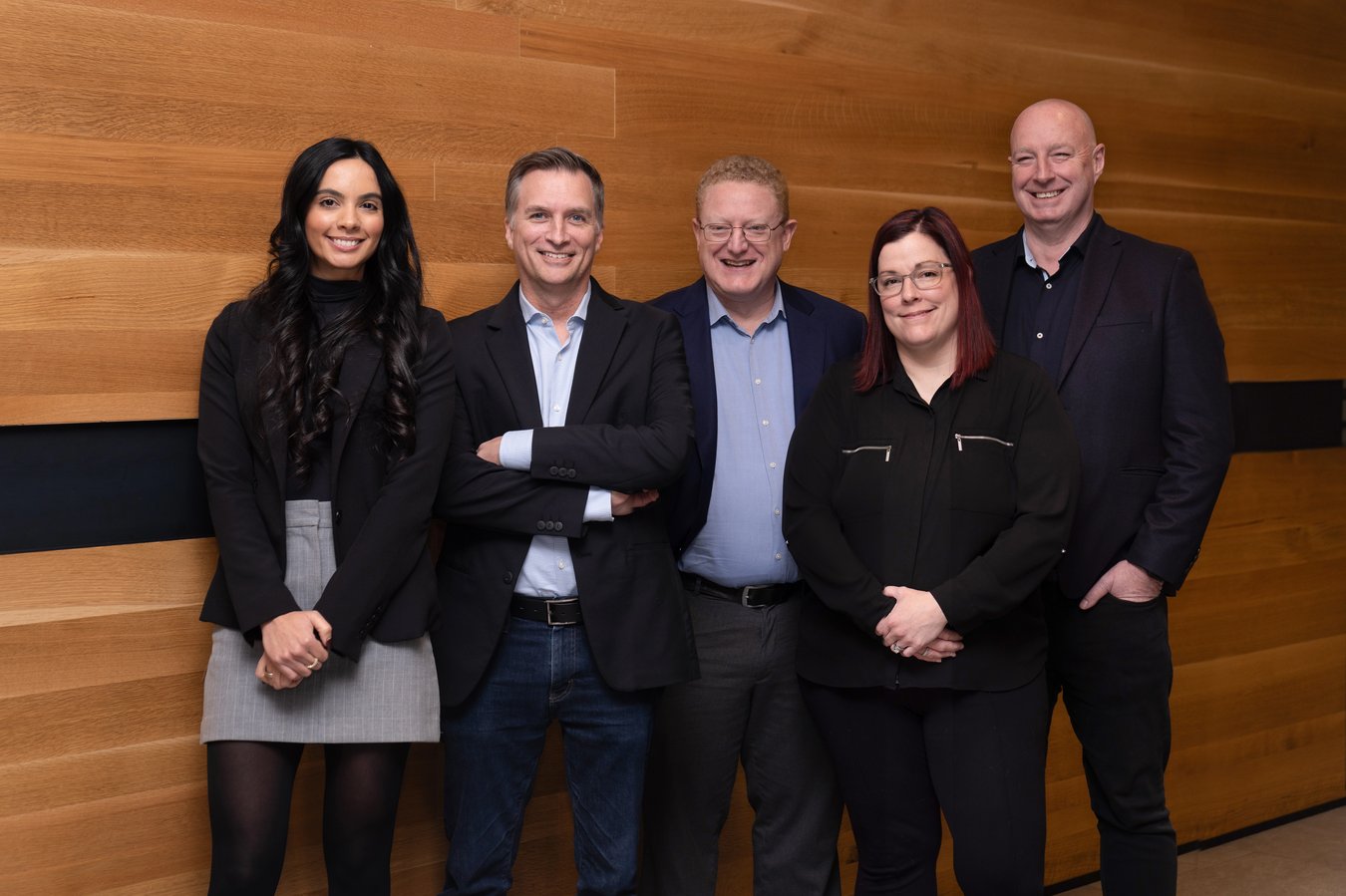 Flextecs team photo with wood background.